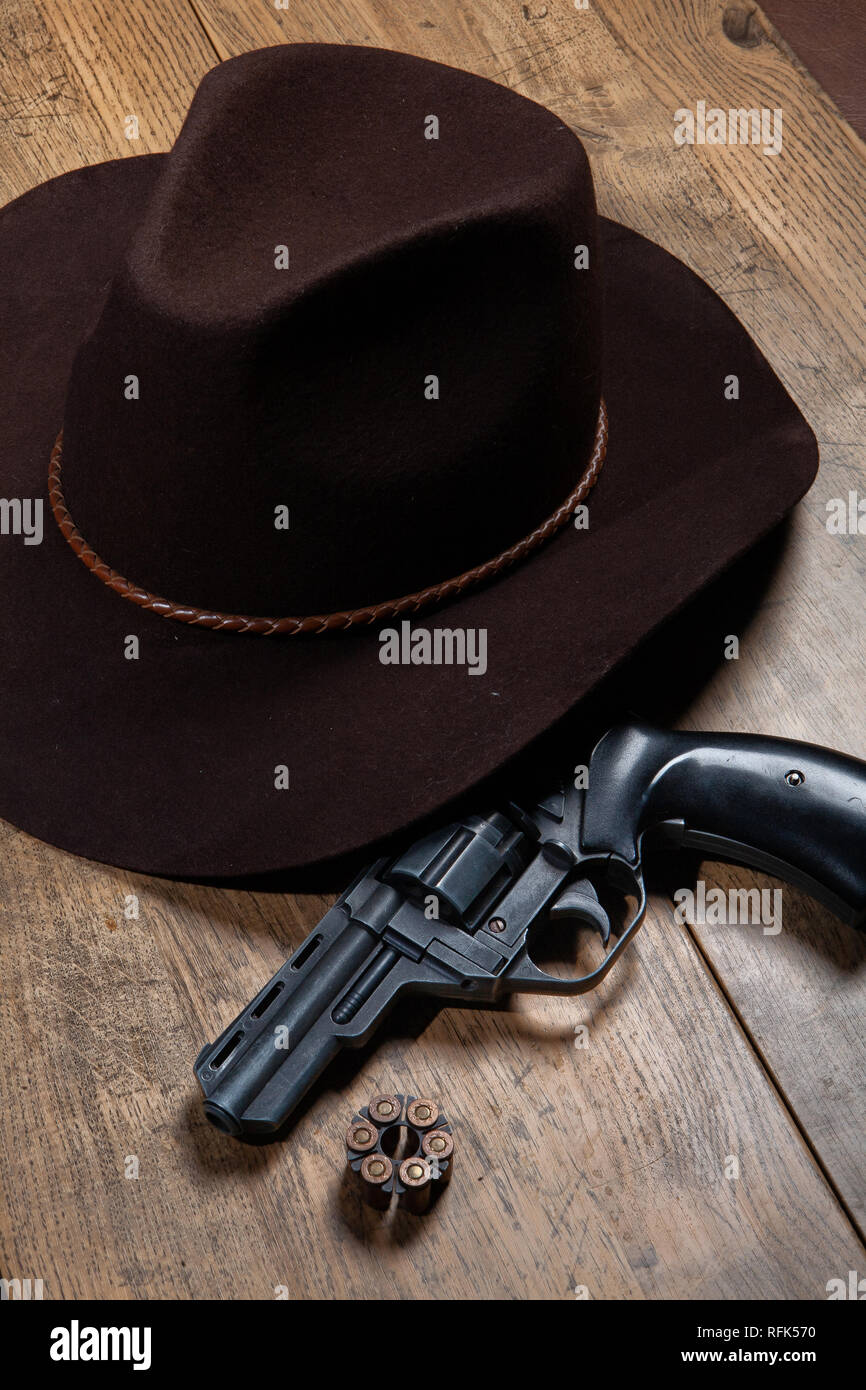 Western chapeau à large et vieux revolver sur un fond de bois Photo Stock -  Alamy