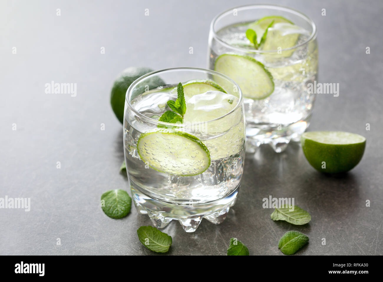 Deux verres de cocktail avec de la chaux sur fond d'ardoise Banque D'Images