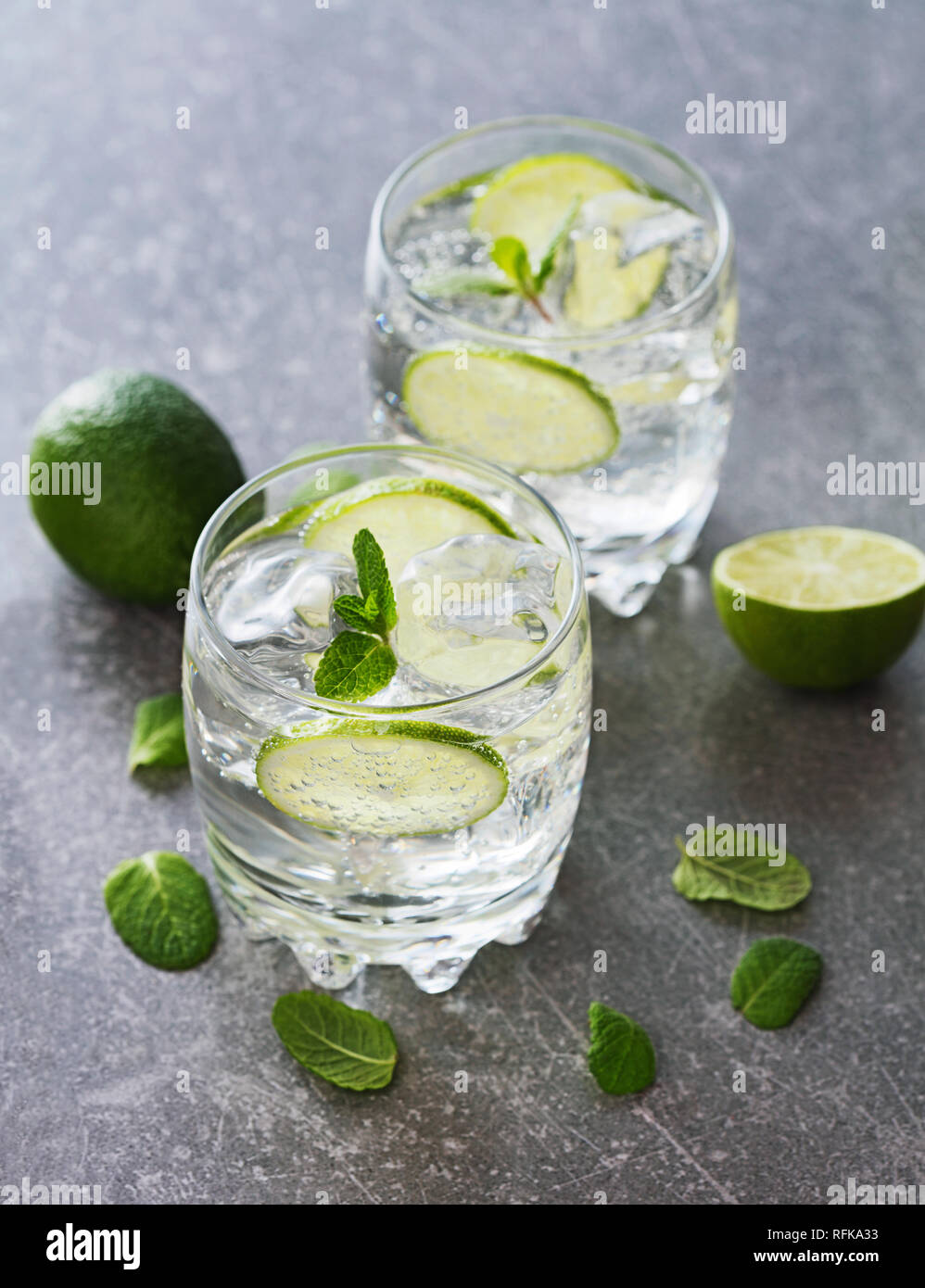 Deux verres de cocktail avec de la chaux sur fond d'ardoise Banque D'Images