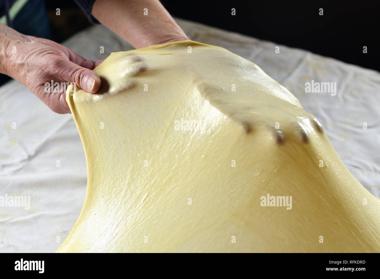 L'étirement de la pâte à gâteau sur une table de cuisine Banque D'Images