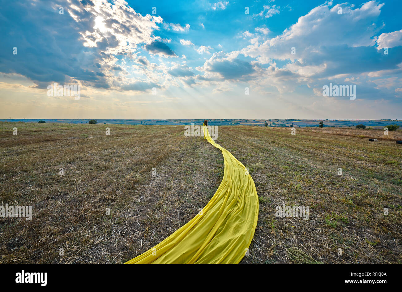 Modèle de fille jaune vêtue pose sur le terrain après la récolte, Kirklareli, Turquie. Banque D'Images