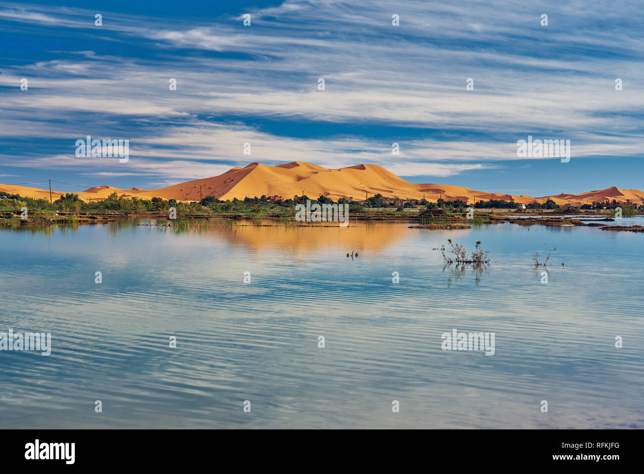 Une colline de sable (dune) d'Erg Chebbi et réflexion sur le lac. Paysage prise près de la ville de Merzouga, Sahara, Maroc en novembre. Banque D'Images