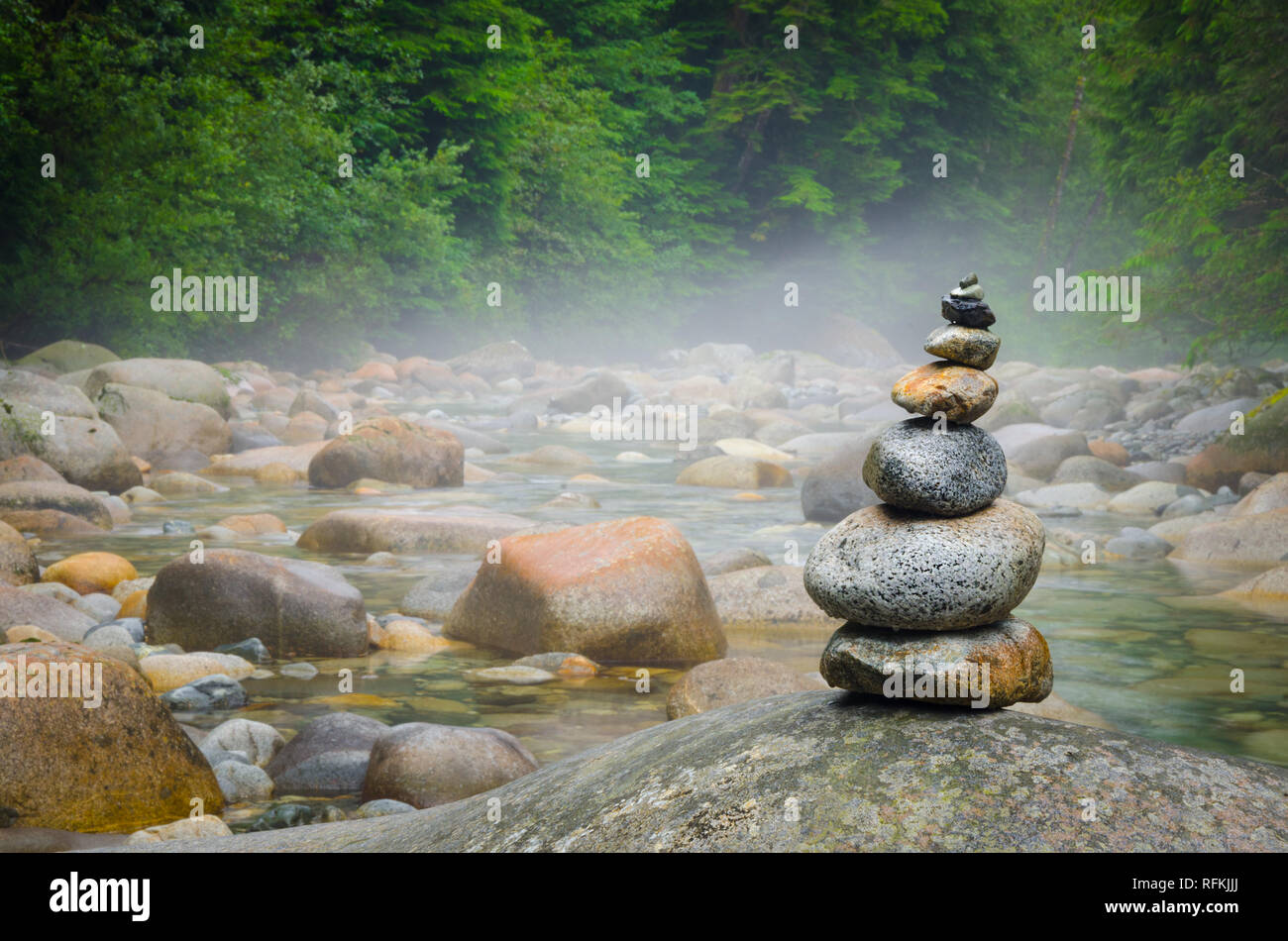 Un petit Inukshuk fait de pierres de rivière à foggy Lynn Headwaters Regional Park, à North Vancouver, Colombie-Britannique, Canada. Banque D'Images