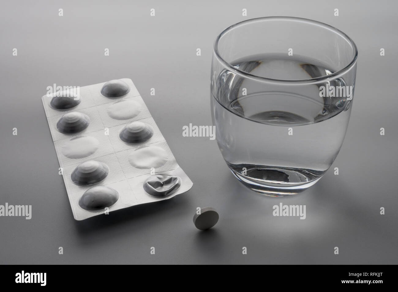 Plaquette de pilules à côté d'un verre d'eau, conceptual image Banque D'Images