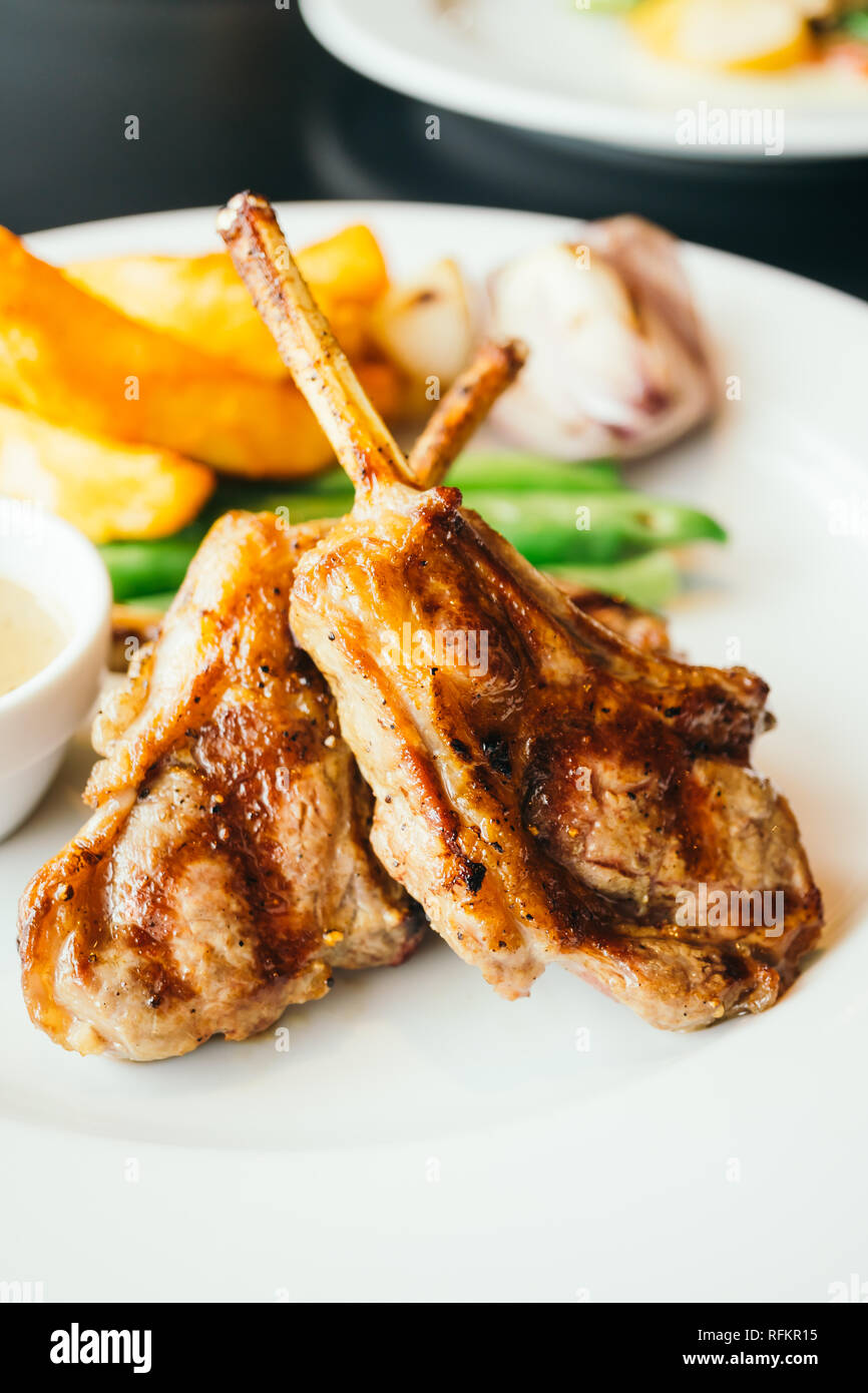 Steaks de viande de l'agneau grillé avec légumes et frites en plaque blanche Banque D'Images