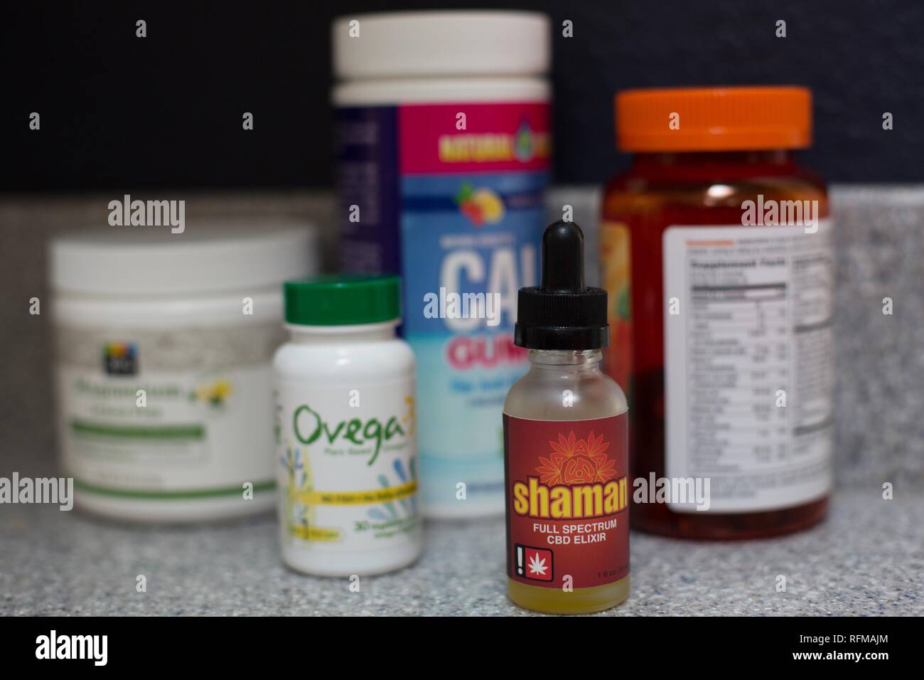 Une bouteille d'huile de la CDB à côté de vitamines et suppléments. Banque D'Images