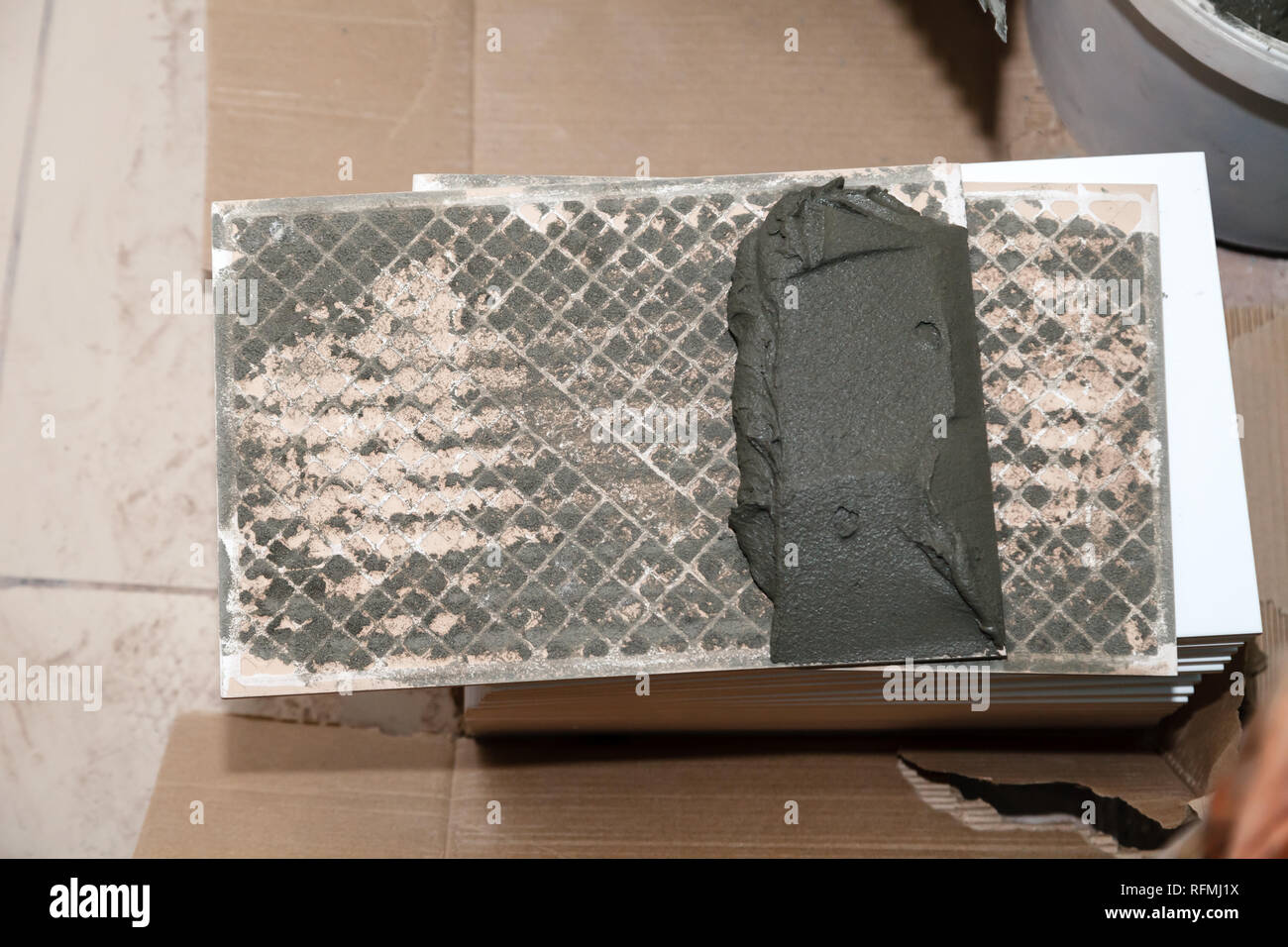 Libre de colle sur la pile de tuiles de céramique dans la salle de bains. Concept Rénovation Réparation, révision, carreleur, contrat de construction d'équipe réparateur Banque D'Images