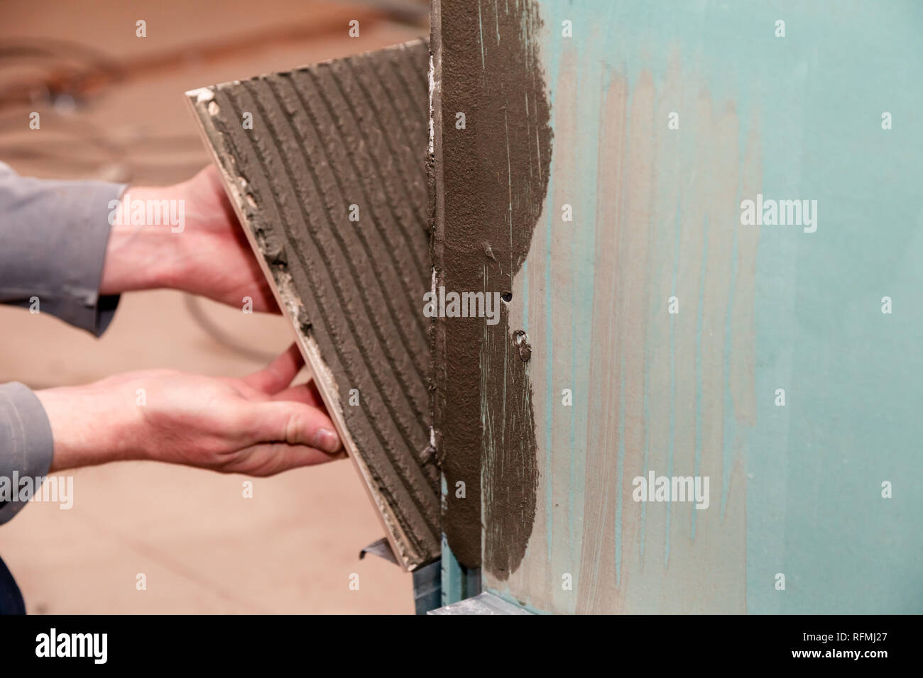 Libre constructeur professionnel de la main de l'homme de colles en carreaux de céramique avec de l'adhésif dans la salle de bains. Concept Rénovation Réparation, révision, carreleur, contrat de l'équipe Banque D'Images