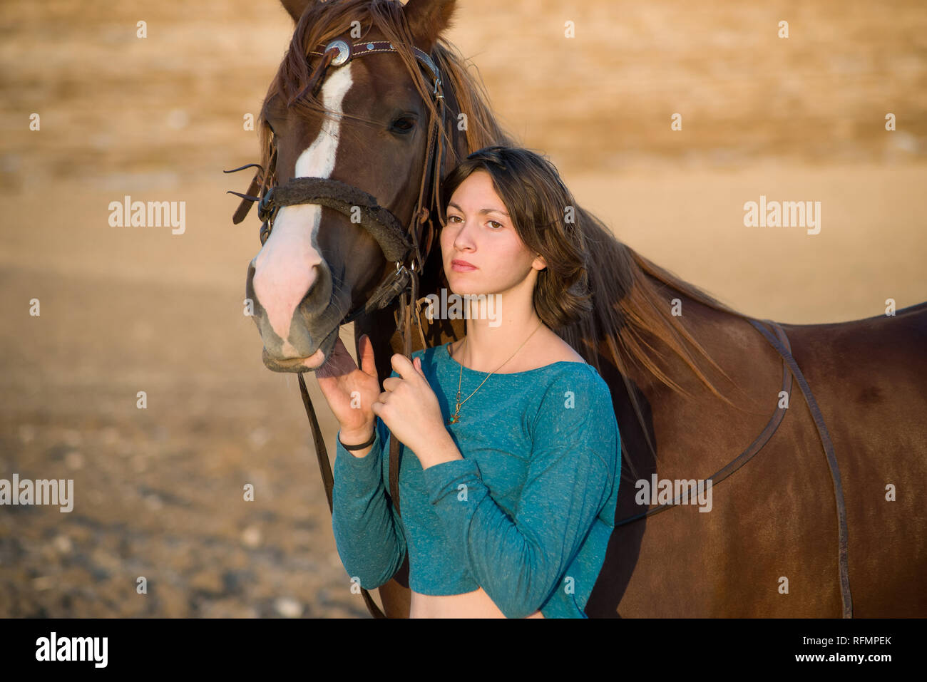 Adolescente et un cheval debout à côté de l'autre regardant le même sens (juste à côté de l'appareil photo) dans la lumière de l'après-midi chaud Banque D'Images