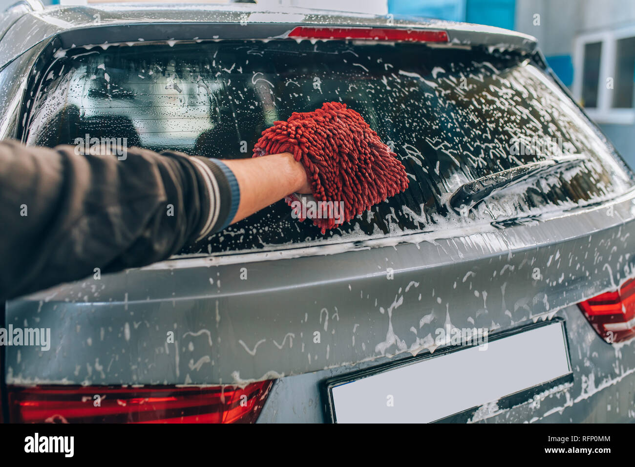 Lavage de voiture et en détail - l'homme tient la main en microfibre et  encaustiques ou laver la voiture. Nettoyage avec éponge homme automobile au  lavage de voiture Photo Stock - Alamy