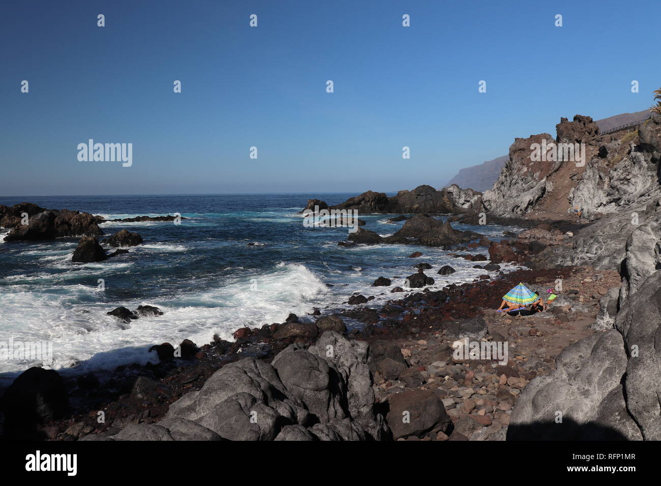 Famille à l'aide d'un parasol à la plage sur une chaude journée d'hiver à Ténérife Banque D'Images