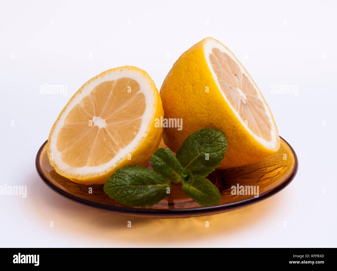 Tranches de citron à la menthe sur un plateau isolé sur fond blanc Banque D'Images