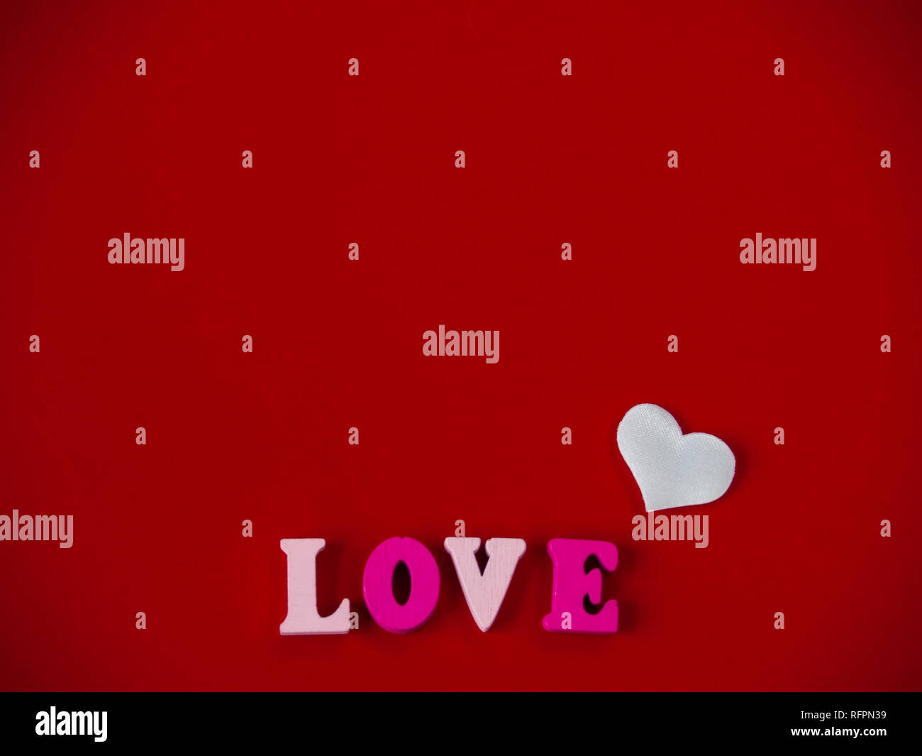 Concept d'amour Le mot amour dans des lettres en bois et les coeurs avec un fond rouge Banque D'Images