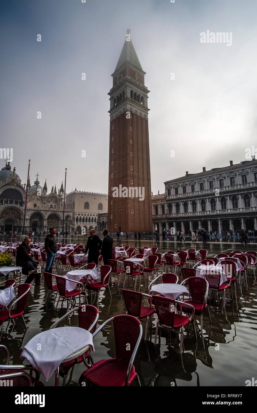 La place San Marco, Piazza San Marco, avec tables et chaises vides d'un restaurant, inondé lors de l'acqua alta Banque D'Images