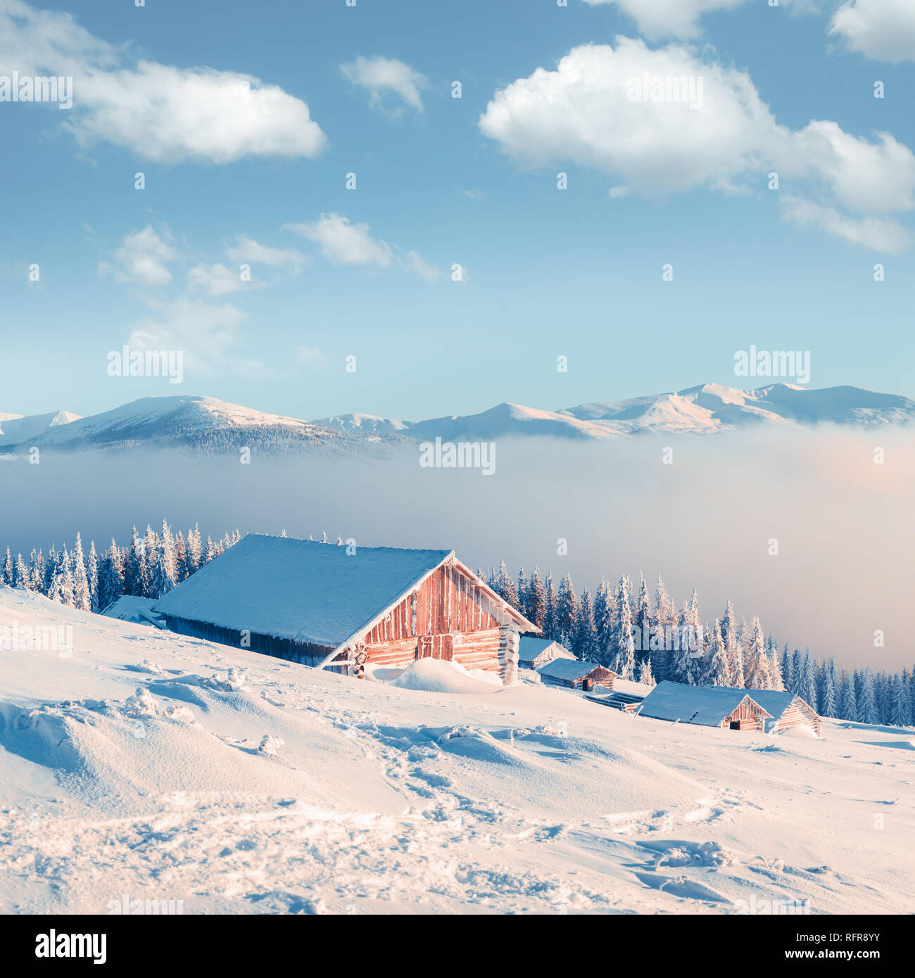 Paysage d'hiver fantastique avec maison en bois dans les montagnes enneigées. Concept de vacances de Noël Banque D'Images