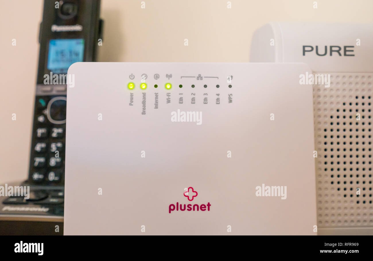 Bureau avec équipement électrique, y compris modem routeur Plusnet montrant une connexion Internet cassée, radio Pure et téléphone sans fil Panasonic Banque D'Images