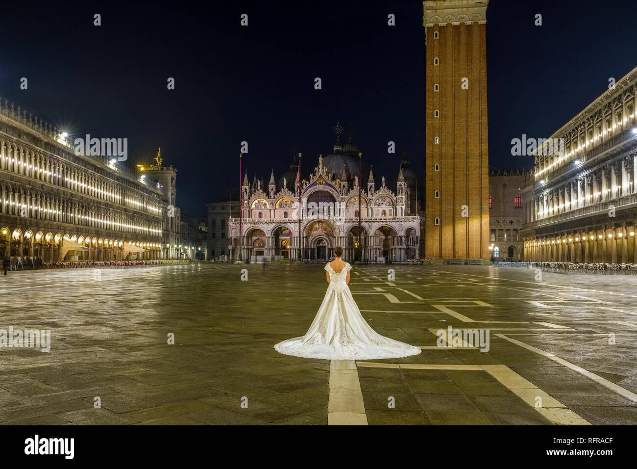 La promise dans une robe de mariage est debout sur la Place San Marco, Piazza San Marco, dans la nuit Banque D'Images
