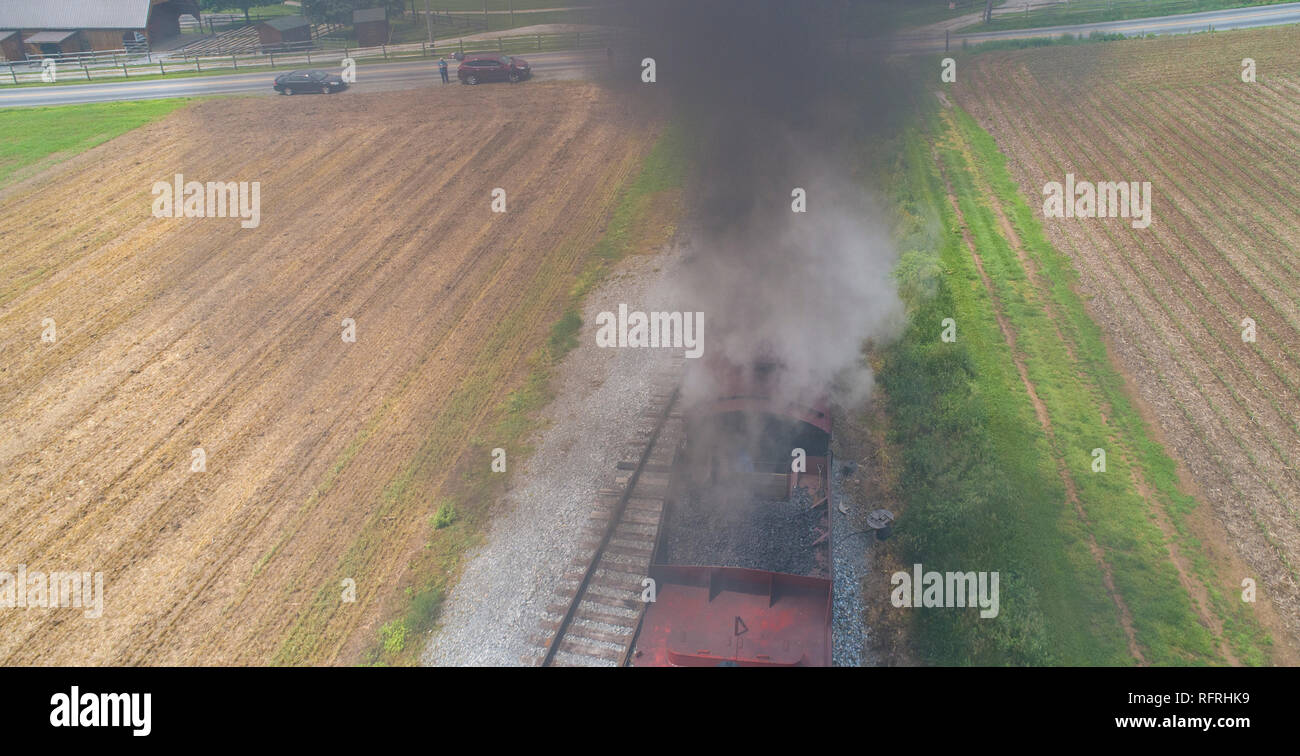 Ariel Vue d'un train de voyageurs en traction à vapeur de pique-nique soufflant de la fumée sur une journée ensoleillée comme vu par un drone Banque D'Images