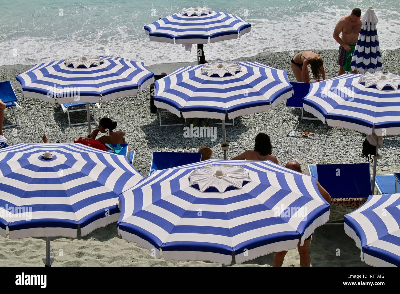 Parasols de plage bleu et blanc sur la Méditerranée en Italie Banque D'Images