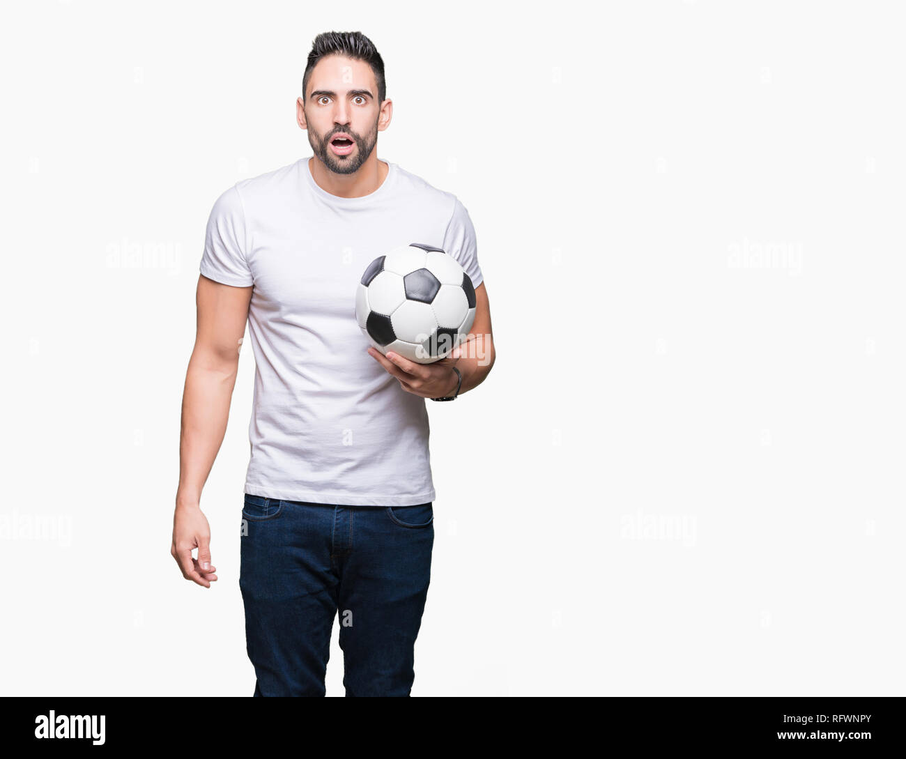 Young man holding soccer ball football fond isolé plus de peur sous le choc avec un visage surpris, effrayé et excité avec crainte expression Banque D'Images