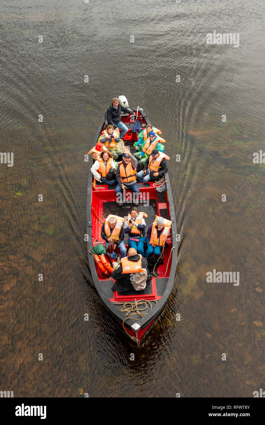 Vue imprenable sur les touristes en bateau à moteur à ramer dans les eaux peu profondes sur le lac Muckross, excursion en bateau dans le parc national de Killarney, comté de Kerry, Irlande Banque D'Images