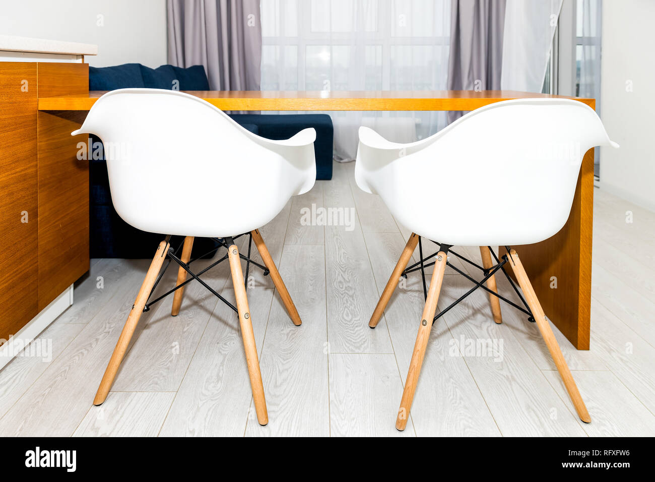 Orange marron en bois moderne est équipée d''armoires dans petit appartement studio avec deux tabourets de bar design intérieur minimaliste et personne dans la maison Banque D'Images