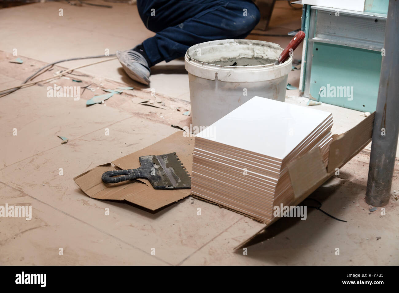 Libre de colle sur la pile de tuiles de céramique dans la salle de bains, busket avec une truelle, ciment colle sur le sol. Concept Rénovation Réparation, révision, contra Banque D'Images