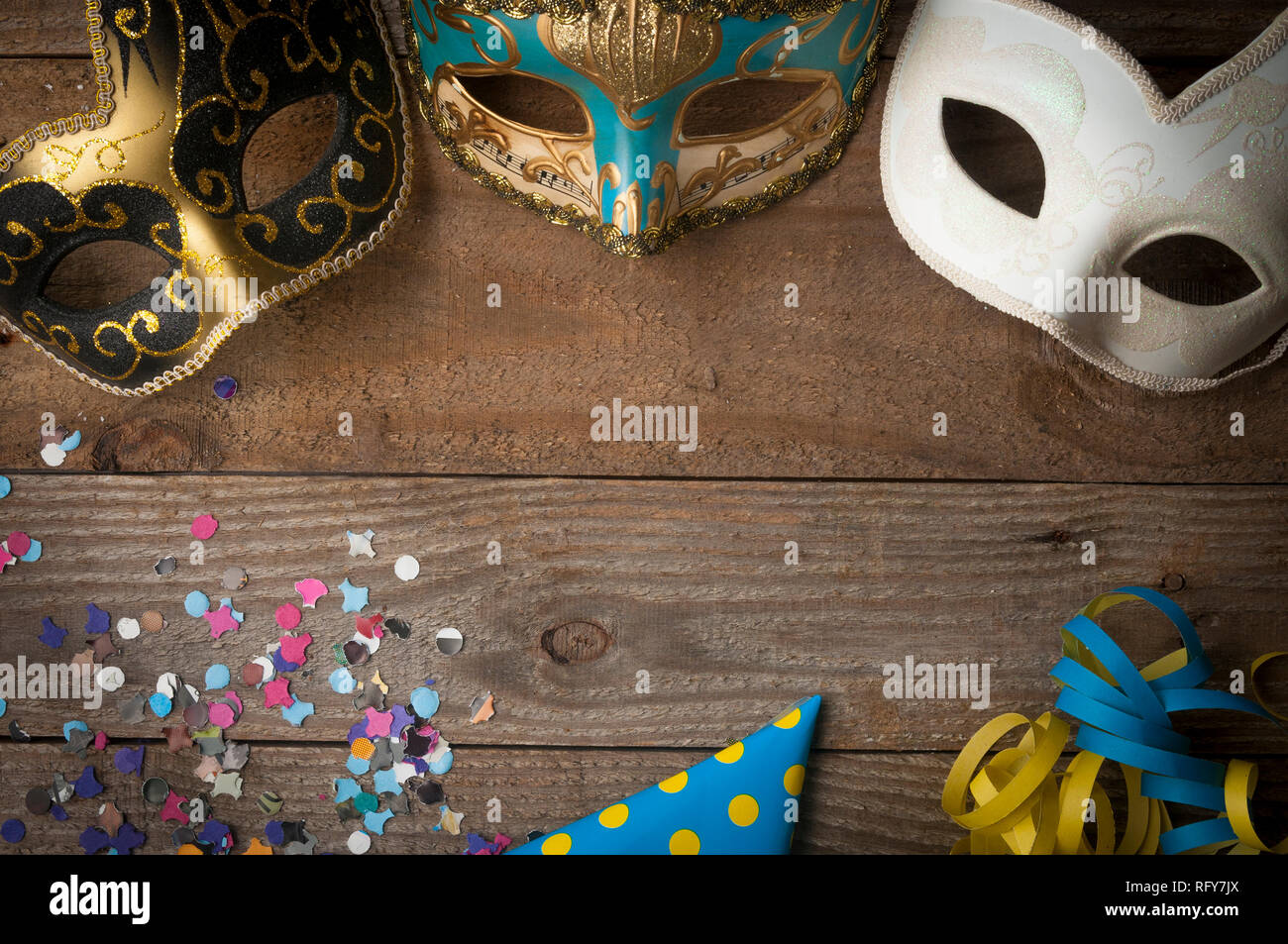 Les masques de Mardi gras sur table en bois avec des Serpentins et confettis Banque D'Images