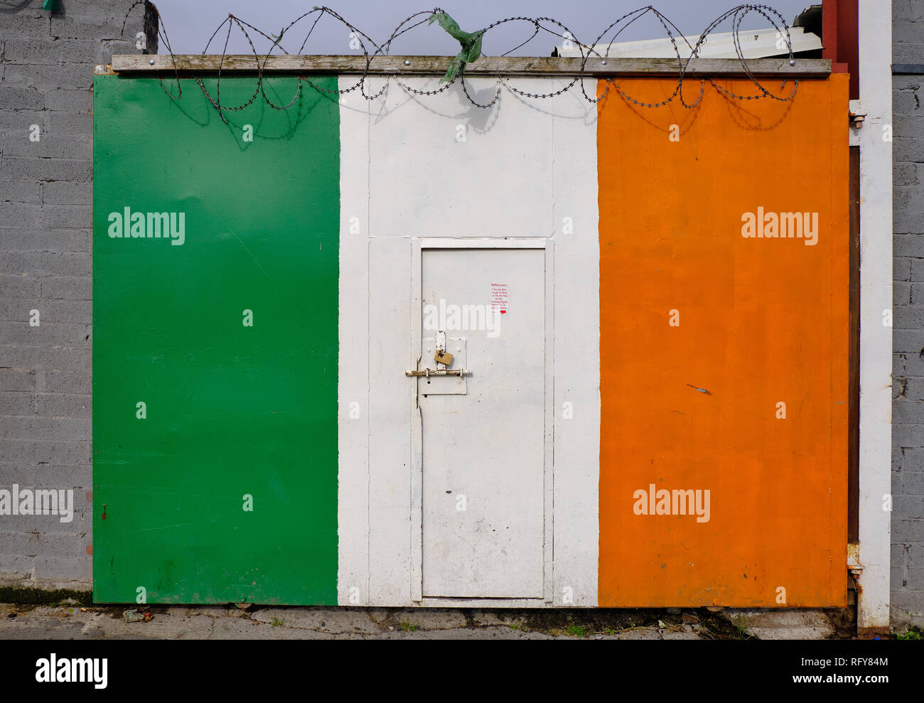 Large porte de garage coulissantes peintes dans les couleurs de l'drapeau irlandais avec Barb fils en haut. Banque D'Images