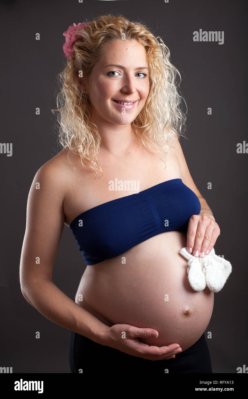 Beauitiful pregnant woman with baby shoes Banque D'Images