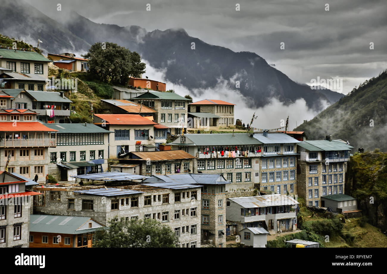 Le mountain village commercial de Namche Bazar au Népal avec ses bâtiments et toits bleus et orange vif au camp de base de l'Everest le long du sentier. Banque D'Images Le mountain village commercial de Namche Bazar au Népal avec ses bâtiments et toits bleus et orange vif au camp de base de l'Everest le long du sentier. Banque D'Images
