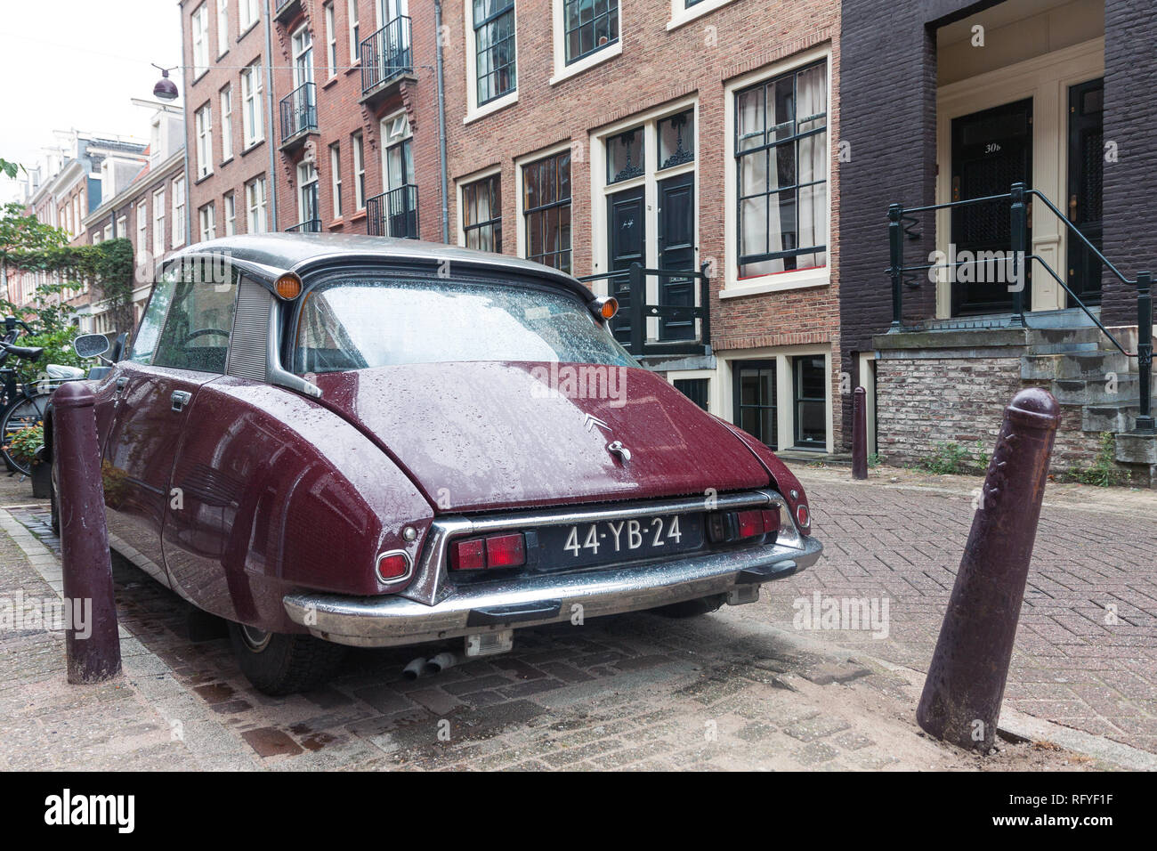 Retro Vintage french Citroen voiture de derrière en stationnement sur la rue de la vieille ville d'Amsterdam sur la saison des pluies Banque D'Images