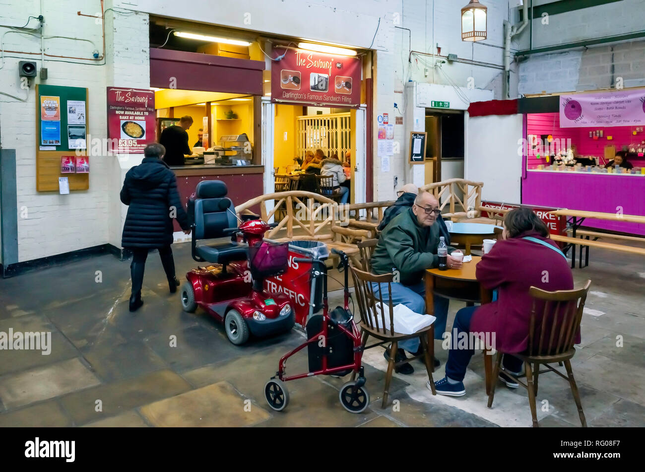 Les clients handicapés bénéficiant d'aides à la mobilité avec un rafraîchissement dans le café du marché couvert de style victorien de Darlington Banque D'Images