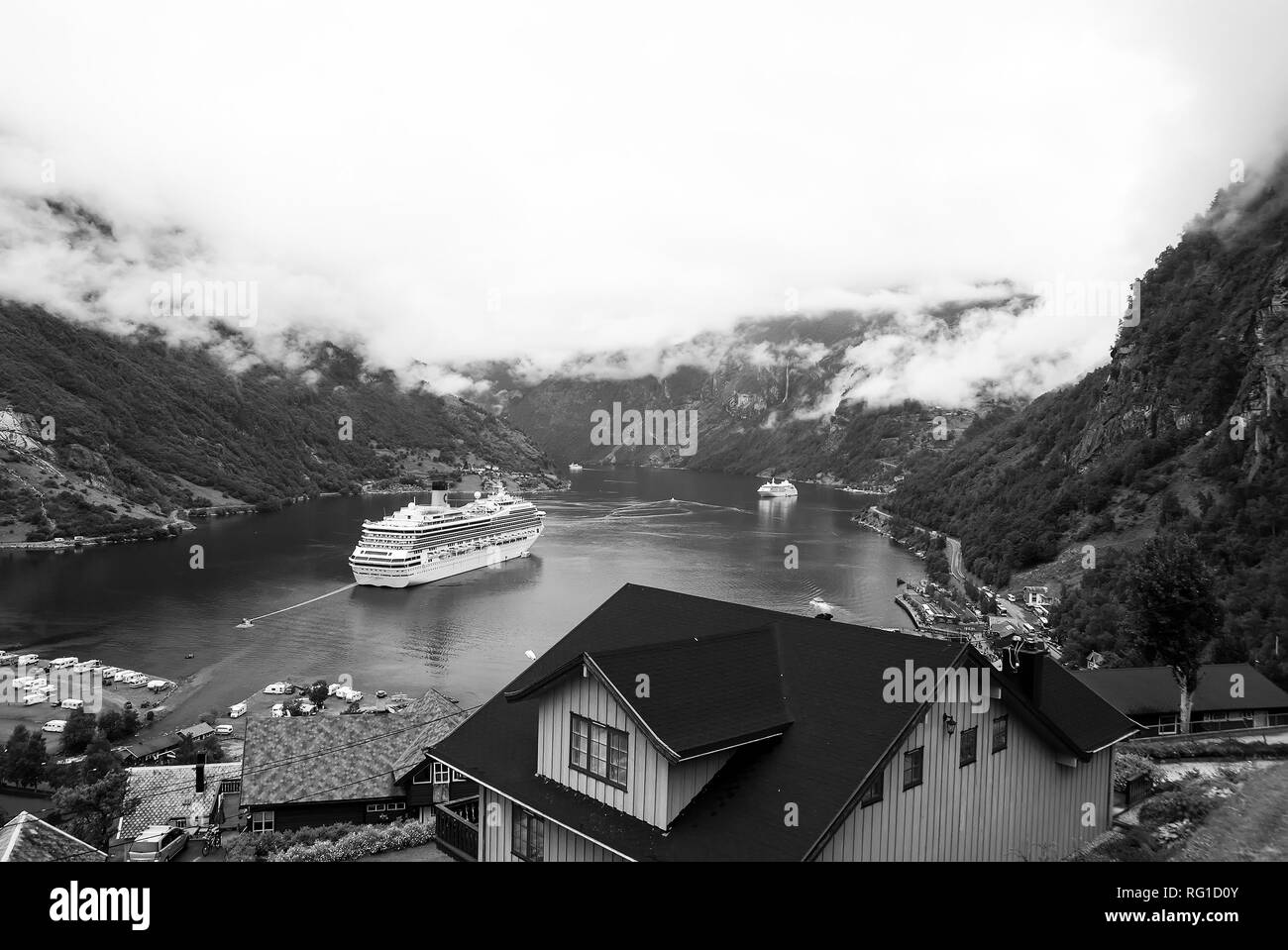 Geiranger, Norvège - le 25 janvier 2010 : destination, le tourisme. Navire au fjord norvégien sur ciel nuageux. Paquebot dans port du village. Destination Voyage, tourisme. Voyage de découverte de l'aventure Banque D'Images