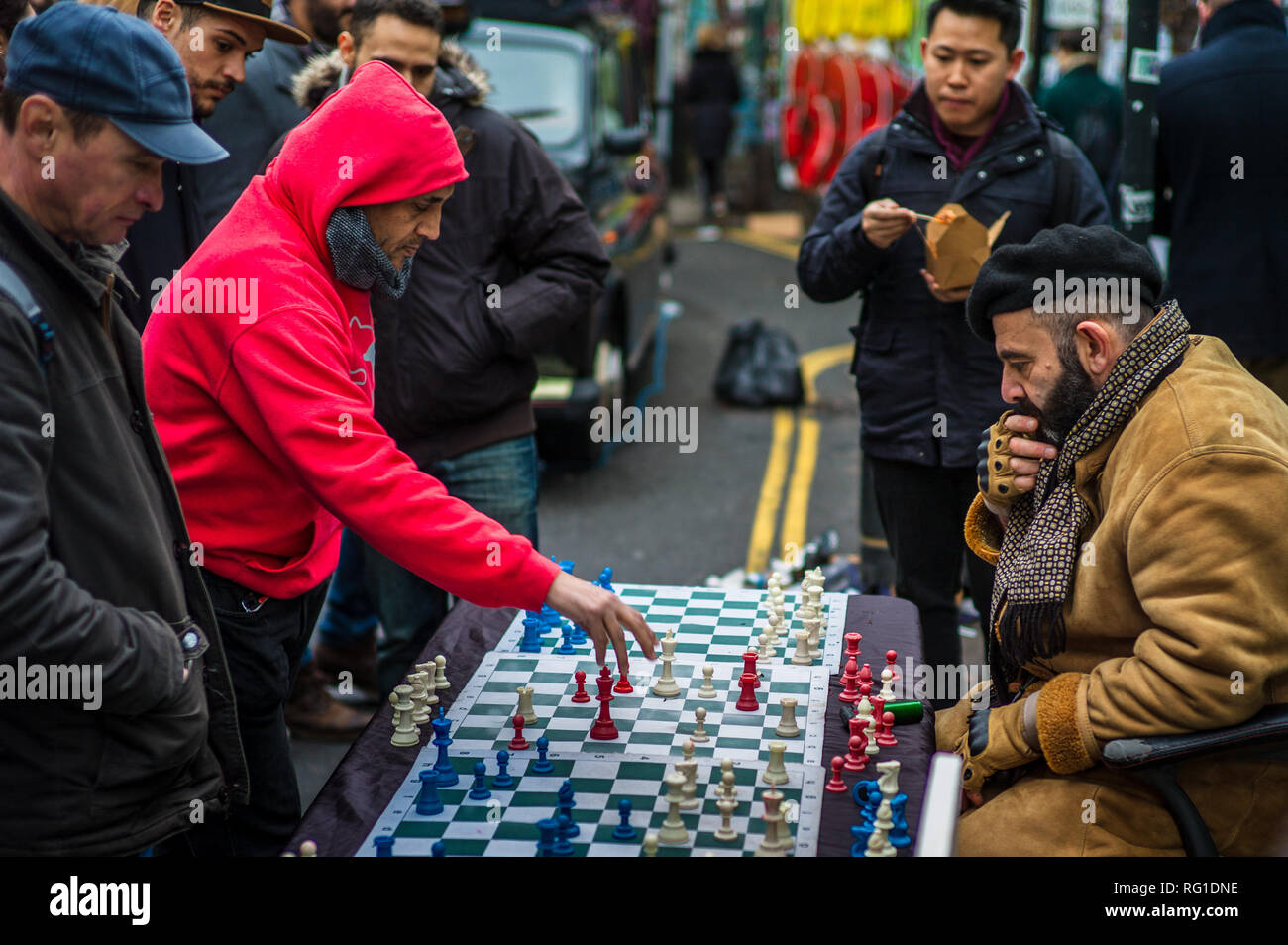 Échecs de Brick Lane Street - un joueur d'échecs joue jusqu'à 4 matches simultanés avec les touristes et les passants dans le marché populaire de Brick Lane Sunday à Londres Banque D'Images