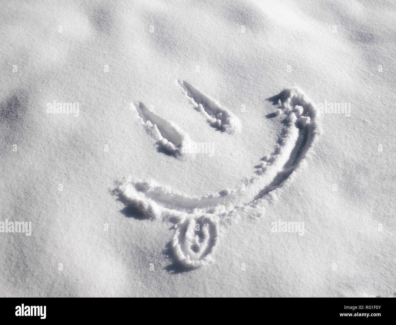 Emoji sourire peint sur la neige, close-up, vue du dessus Banque D'Images