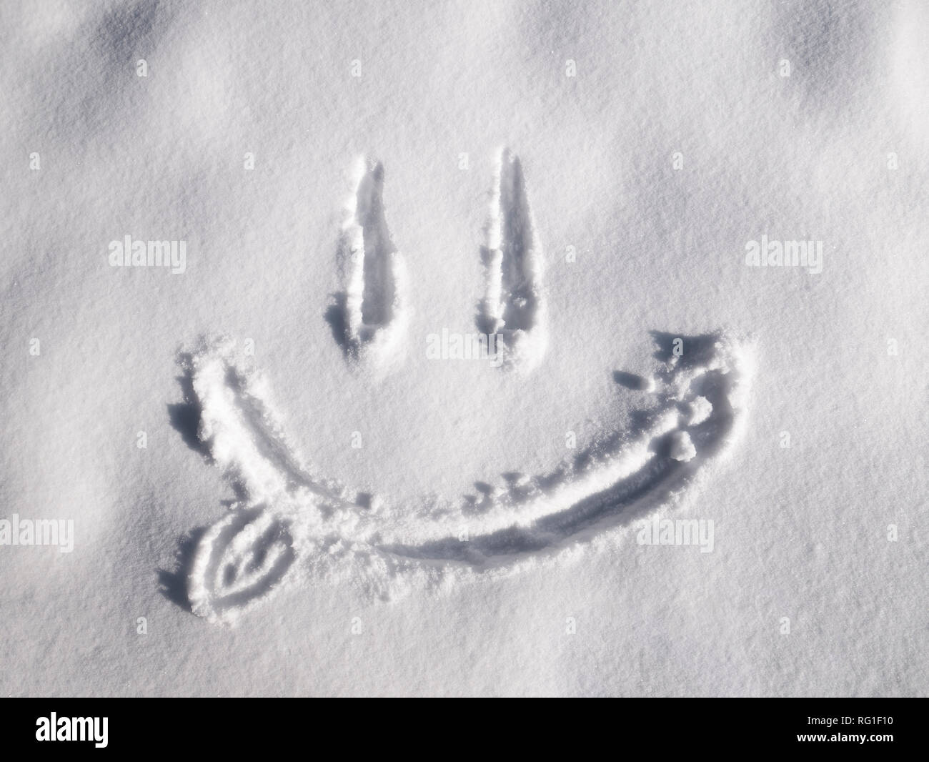 Emoji sourire peint sur la neige, close-up, vue du dessus Banque D'Images