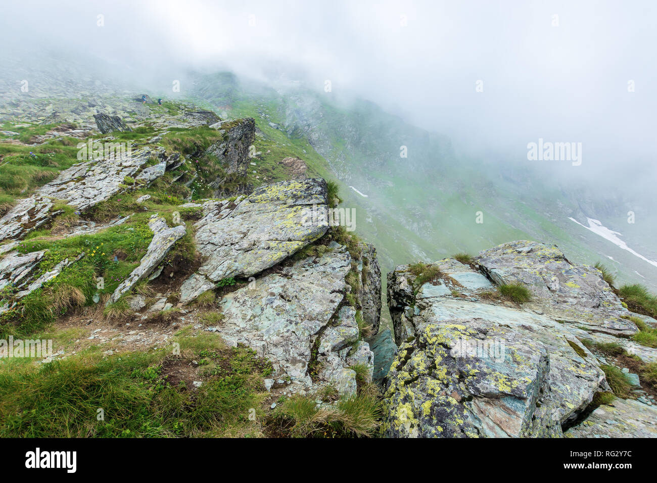 Sur le bord d'une falaise rocheuse de la crête Fagaras mystérieux. paysages de montagnes roumaines dans un épais brouillard. beau paysage d'été populaires Voyage. destina Banque D'Images