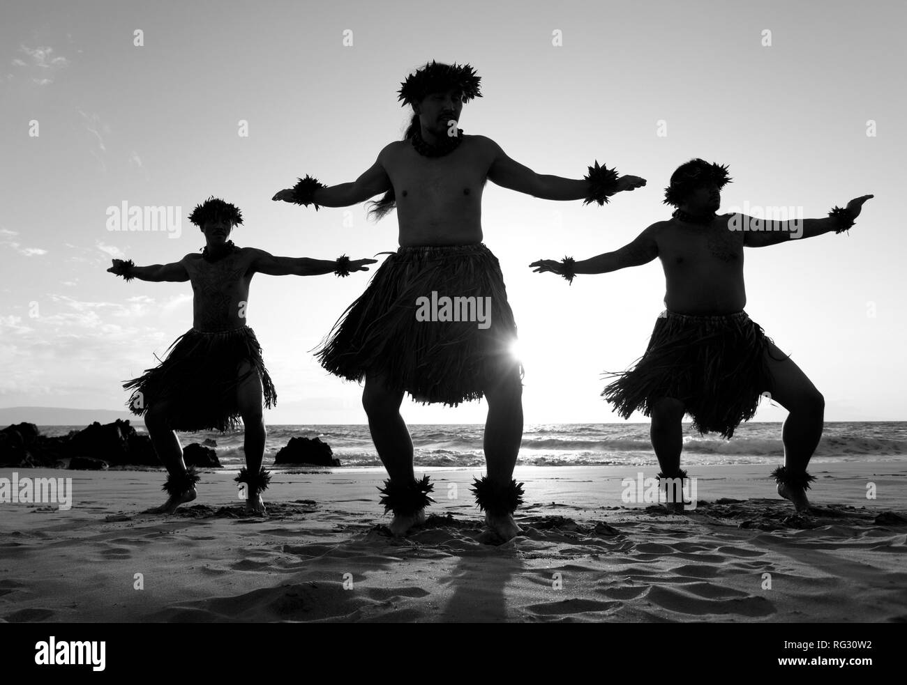 Trois danseurs hula mâle sur la plage à Chang's Beach, Maui, Hawaii. Banque D'Images