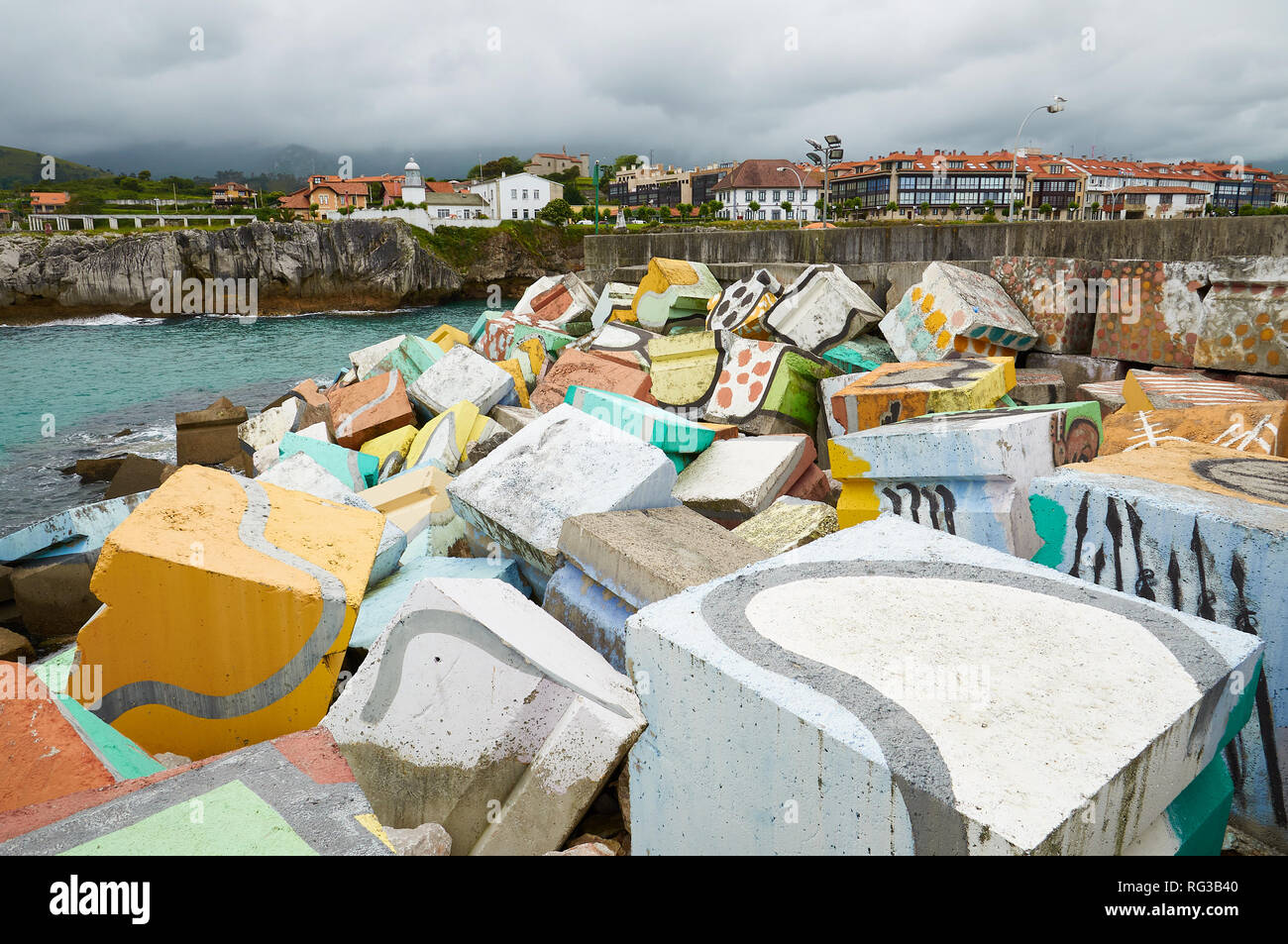 Cubos de la Memoria, intervention artistique d'Agustín Ibarrola de blocs de béton peints avec ville à l'arrière dans le port de Llanes (Asturies, Espagne) Banque D'Images