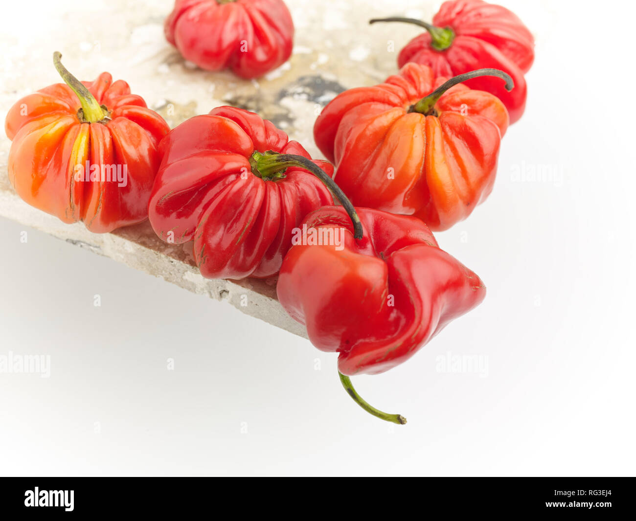 Poivre Scotch Bonnet tacheté et surface en marbre contre fond clair. Photographie alimentaire Banque D'Images