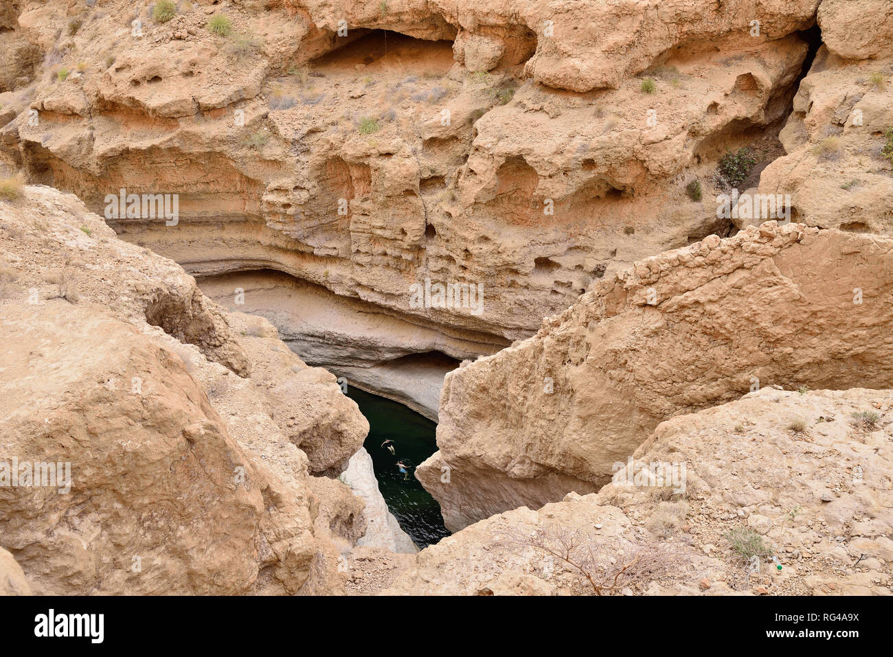 Les touristes de prendre un bain avec de l'eau vert émeraude sur le Wadi Shab. Cette vallée est un des plus étonnants en Oman Banque D'Images