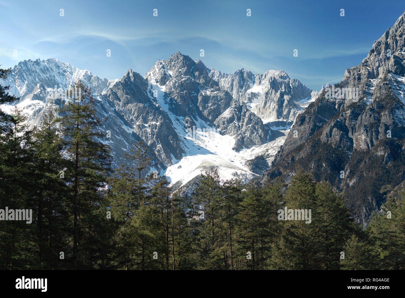 Montagne Enneigée du Dragon de Jade situé dans le Yunnan, Yulong la Chine. La montagne couverte de neige avec des pics rocheux avec les arbres en premier plan en donnant une forte Banque D'Images