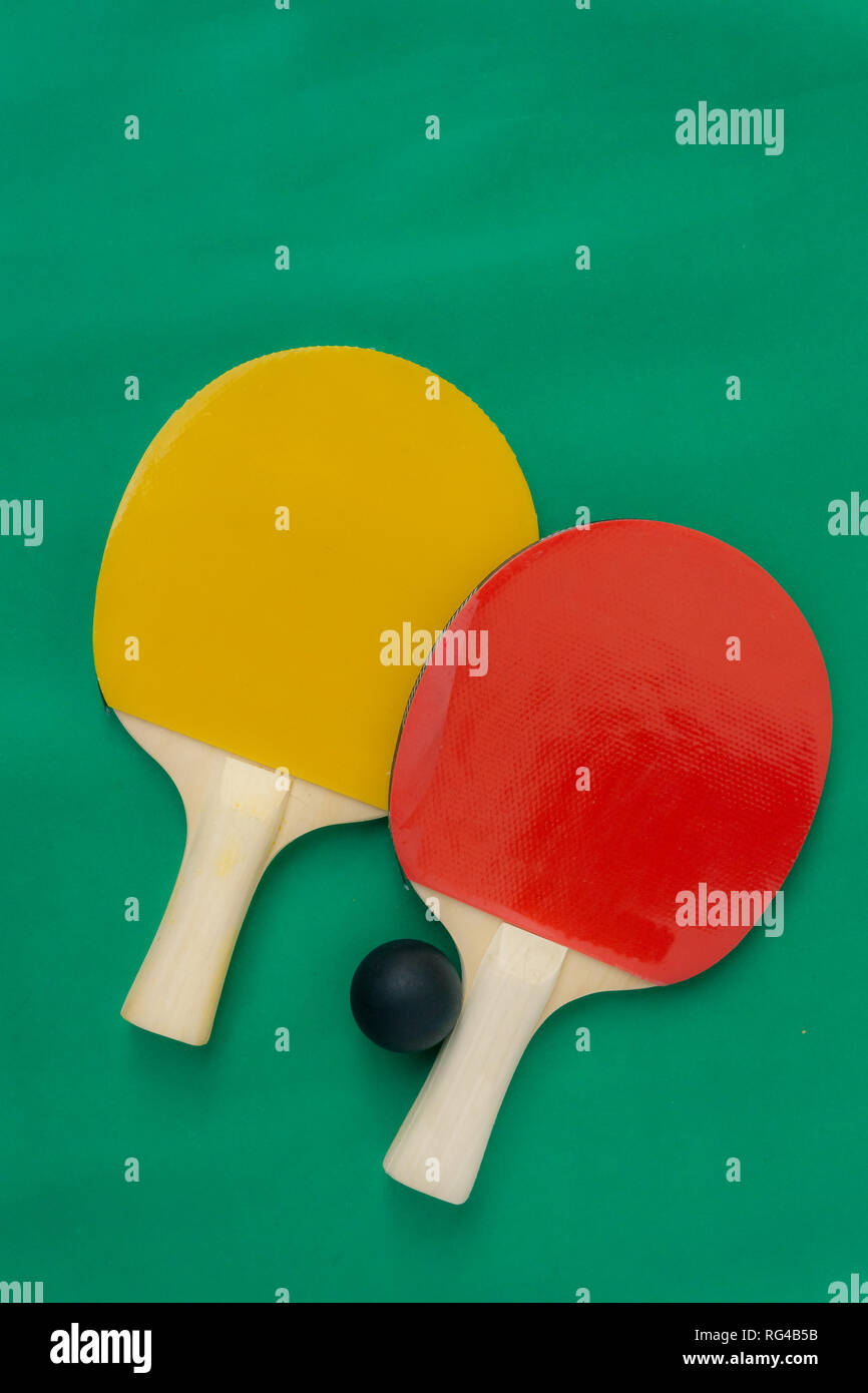 Le rouge et le jaune des raquettes de tennis de table avec des boules NOIRES, tennis de table raquettes et balles sur la table. Banque D'Images