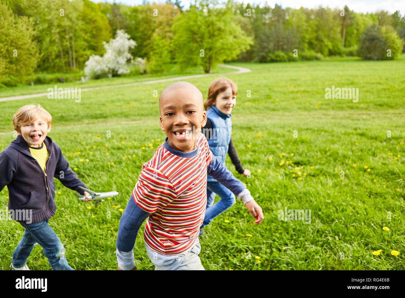 Les enfants comme des amis jouer ensemble sur une prairie dans le parc sur une partie d'anniversaire pour enfants Banque D'Images