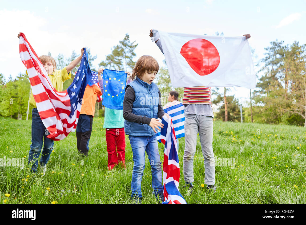 Groupe d'enfants dans la région de camp international de la jeunesse avec différents drapeaux nationaux Banque D'Images