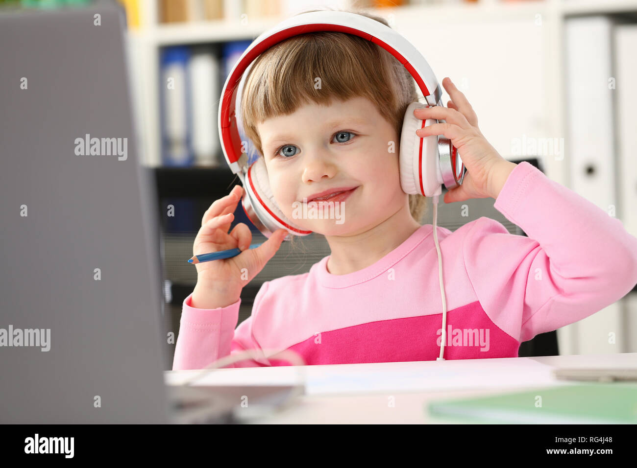 L'enfant assis au casque satisfait Banque D'Images