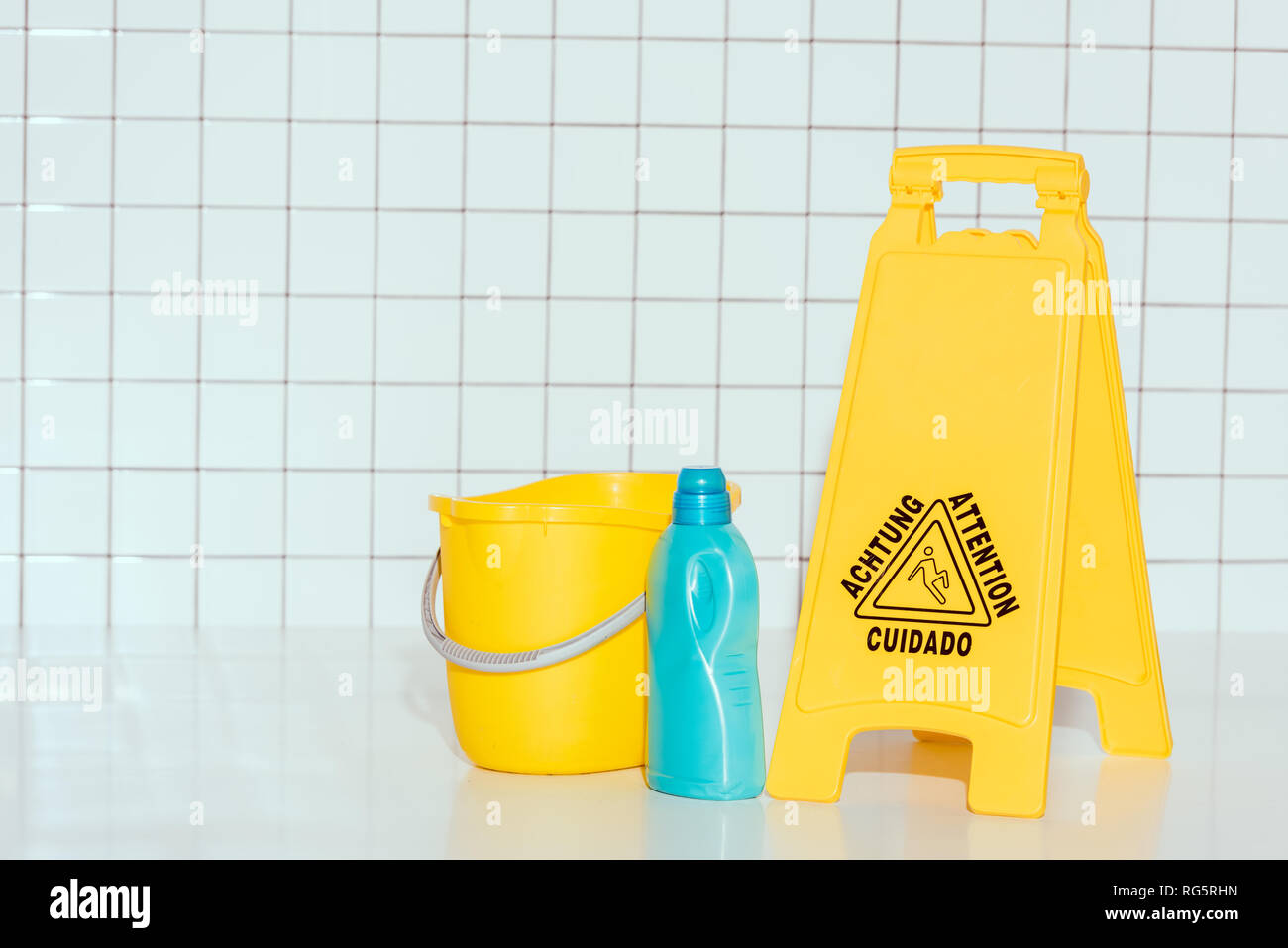 Focus sélectif du matériel de nettoyage et 'Attention' dans la salle de bains Banque D'Images