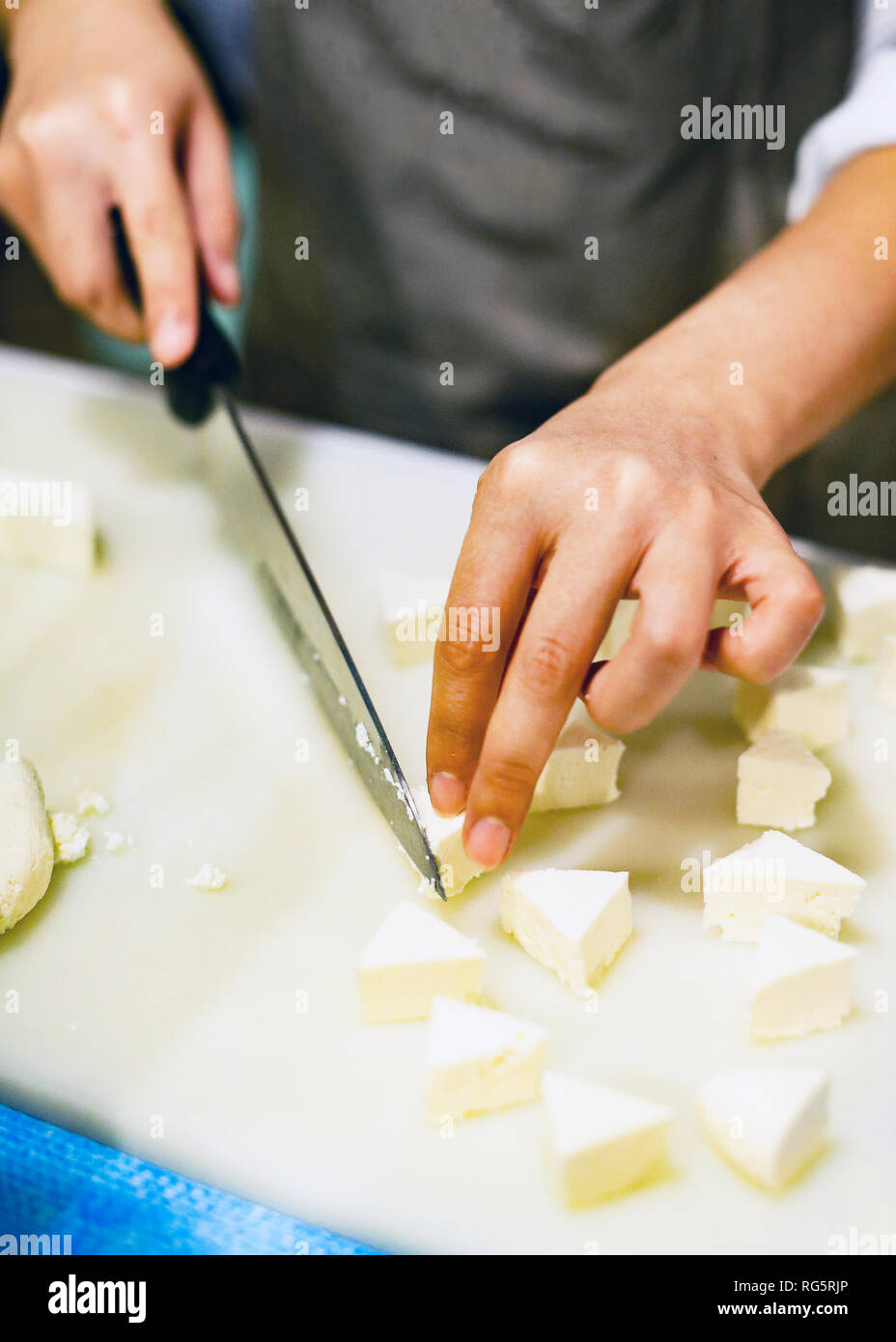 Chef de trancher le tofu pour la cuisine, cuisinier, la cuisson des aliments dans la cuisine, le tofu frais Banque D'Images