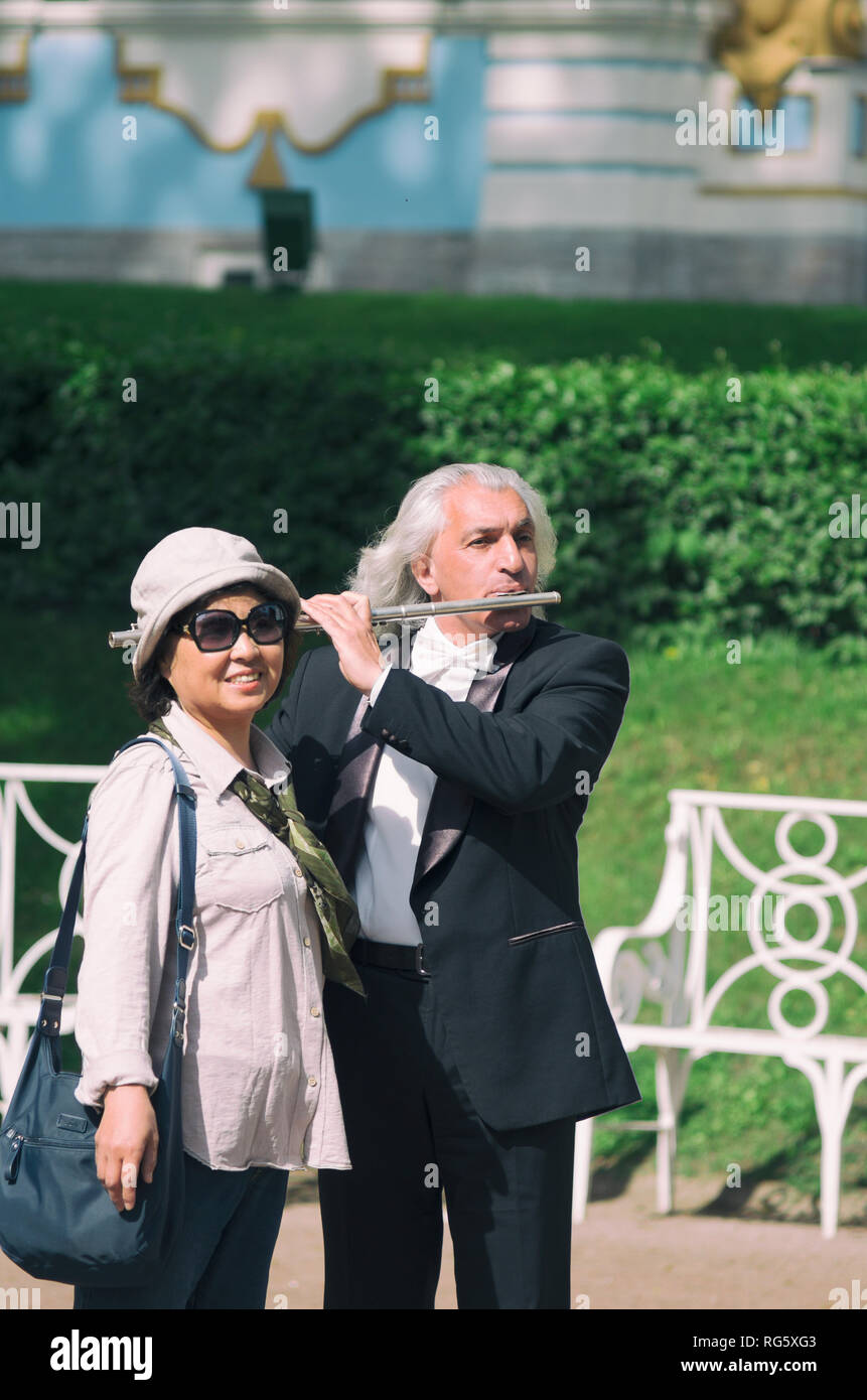 Tsarskoye Selo, Saint Petersburg, Russie - 20 mai 2016 : Asian woman photographiés avec un musicien de rue jouer de la flûte. Banque D'Images